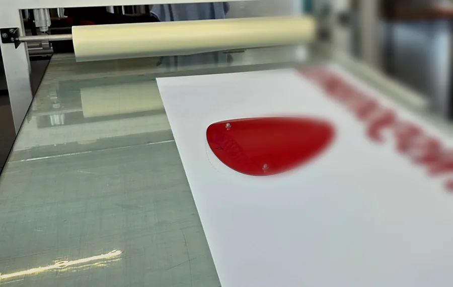 Rote Acrylbuchstaben in der Weiterverarbeitung auf einem Arbeitstisch bei SCHNEIDLING